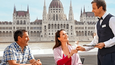  A couple being served Champagne by a butler on the deck of a Scenic cruise ship in Budapest, Hungary