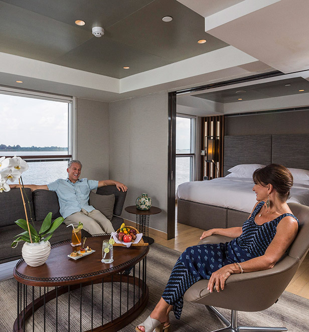 A man and woman sitting down in the separate lounge area of the Royal Panorama Suite