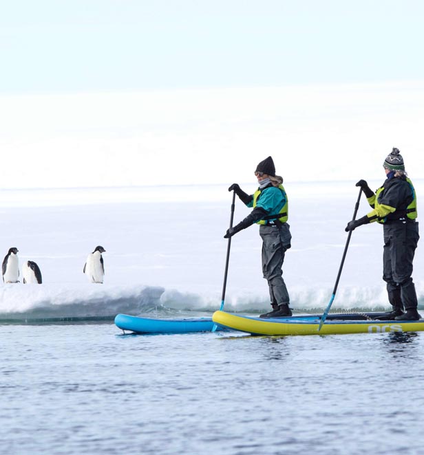 Scenic Eclipse guests standup paddleboarding in Ross Sea, East Antarctica