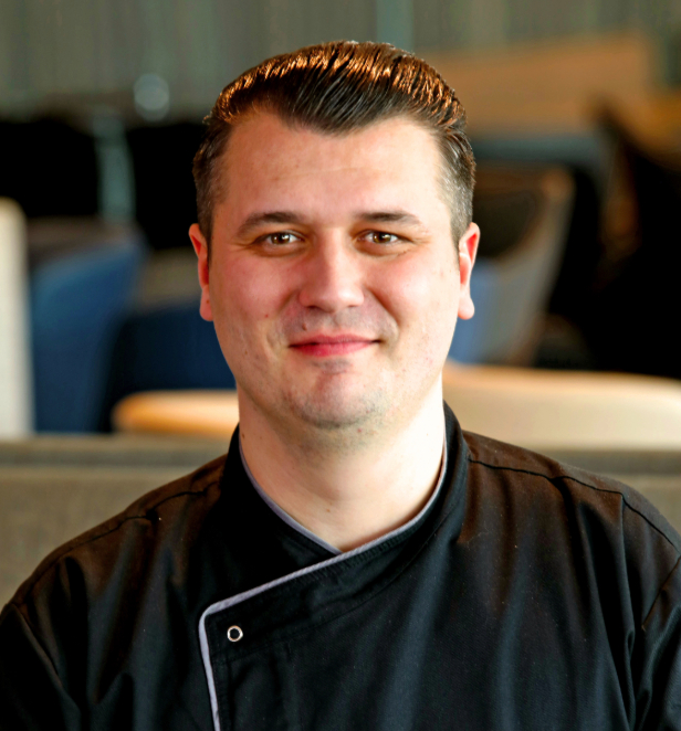 Scenic Executive Chef Jhony Purice displayed looking cheerful in a headshot style image.