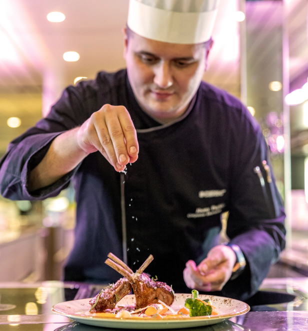 A skilled chef meticulously prepares a beautifully plated dish, highlighting the artistry of fine dining.