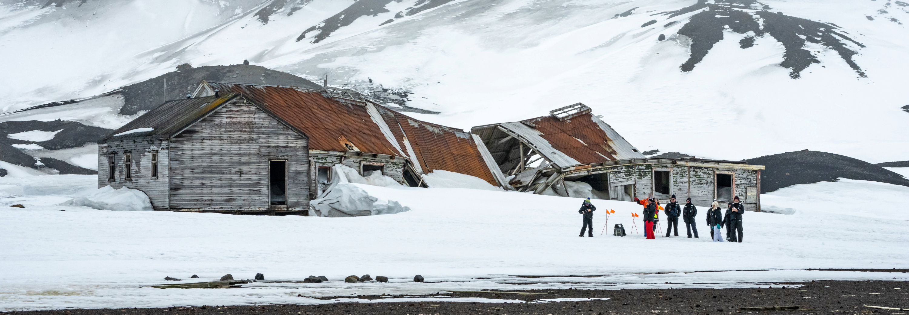 Group of guests visiting abandoned whaling station on Deception Island in Antarctica