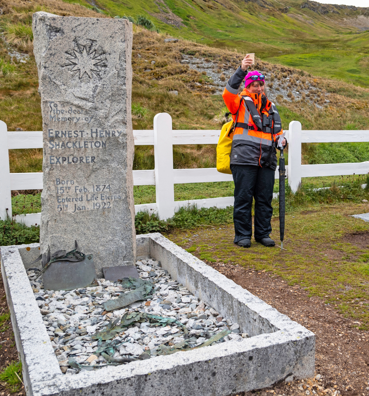 A woman raising a glass at the Memorial of Sir Ernest Shackleton.