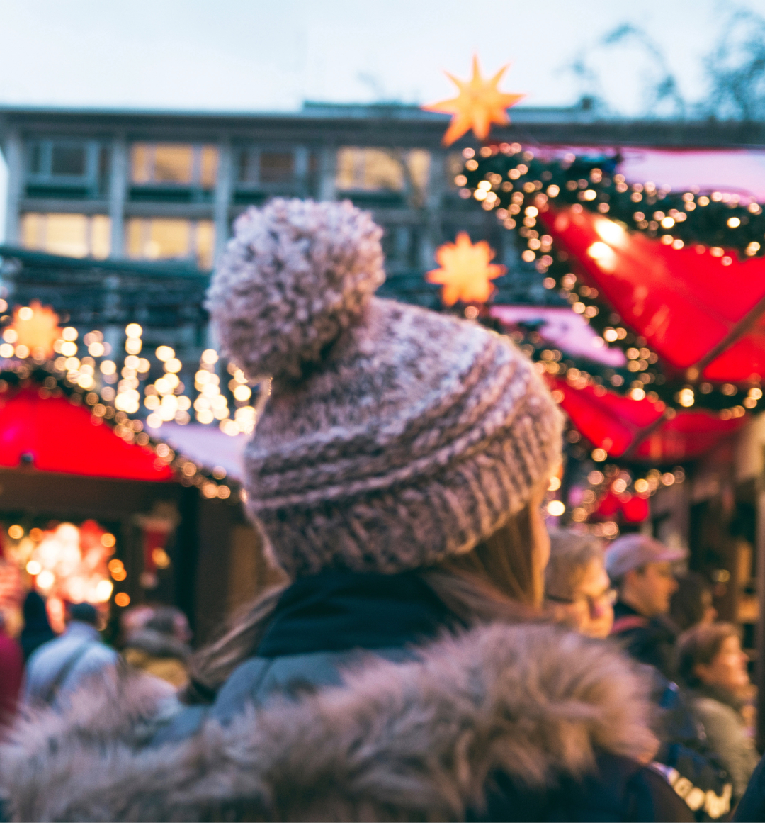 Woman browsing Christmas markets in woolly hat and warm coat