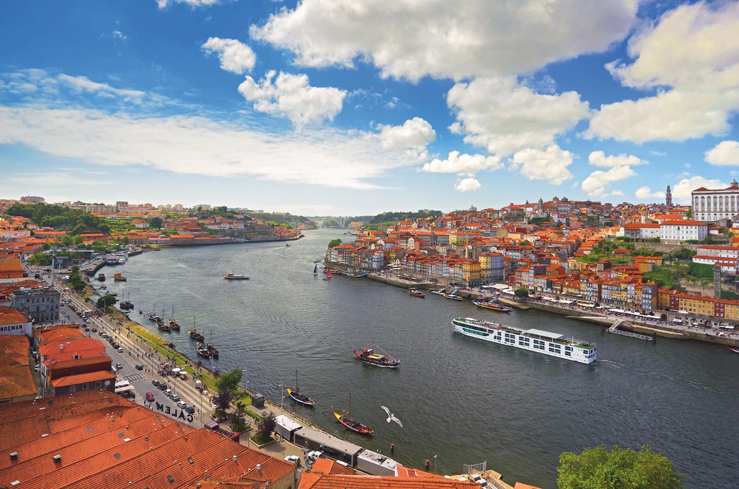 Scenic Azure sailing away down the Douro river in Portugal with colourful houses along the banks and a blue sky with some cloud