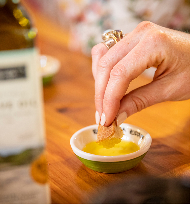Dipping bread in oil on a tasting tour in Waiheke, Auckland