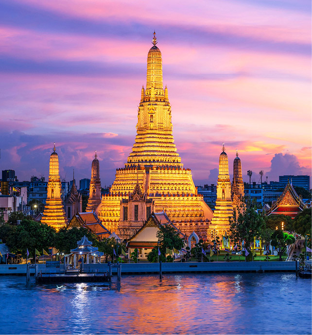 The Wat Arun temple lit up at dusk on the bank of the Chao Phraya River