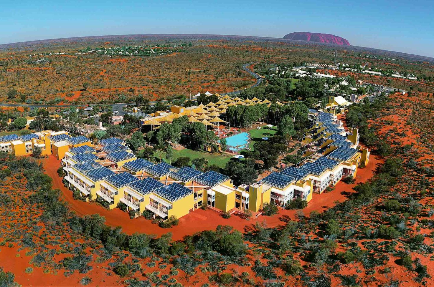 An aerial shot of the Sails in the Desert hotel in Yulara with Uluru in the background
