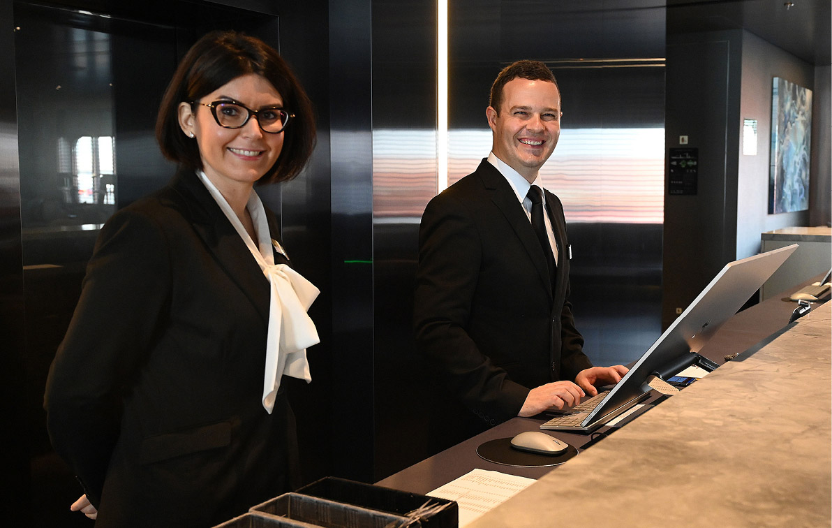 Man and women standing at the front desk