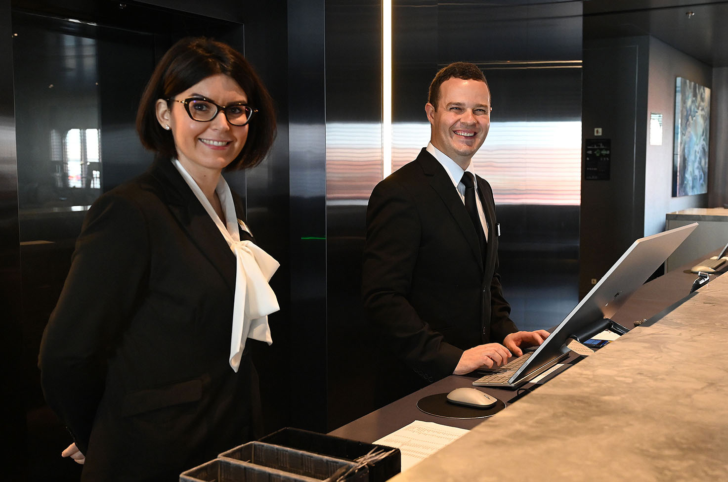 Man and women standing at the front desk