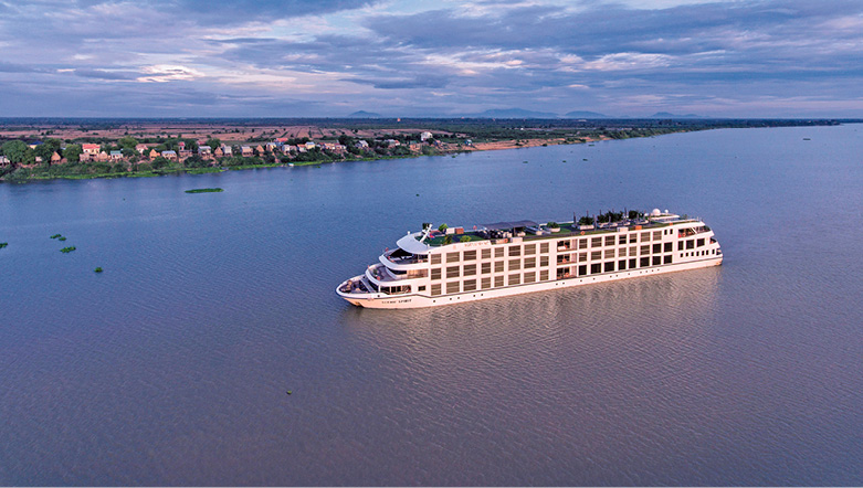 aerial shot of a river cruise ship sailing down the mekong river at sunset