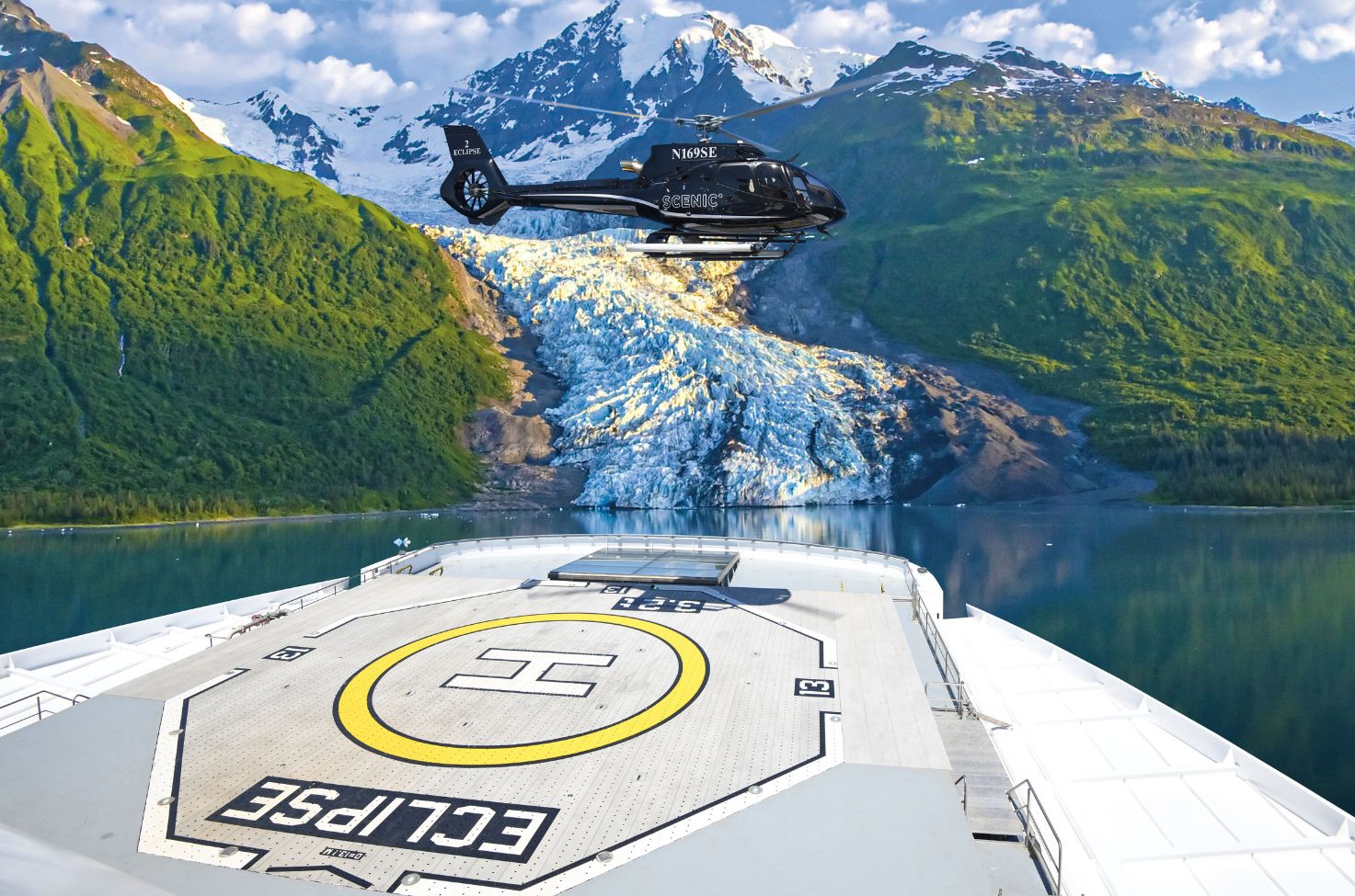 helicopter launching from a helipad on the back of a cruise ship in front of a glacier